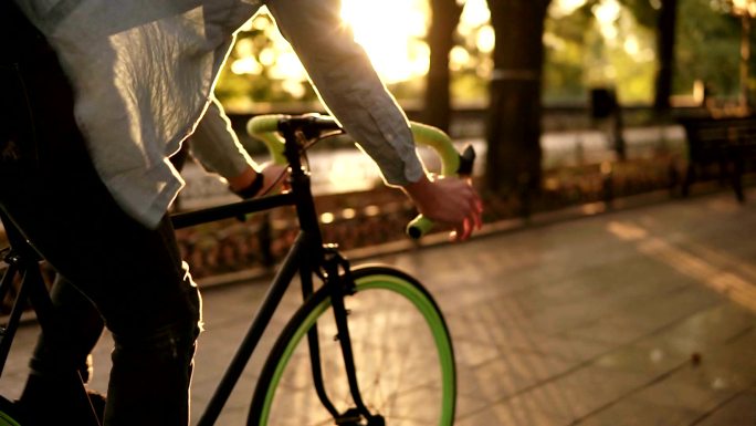 男子在晨间公园或林荫大道骑自行车