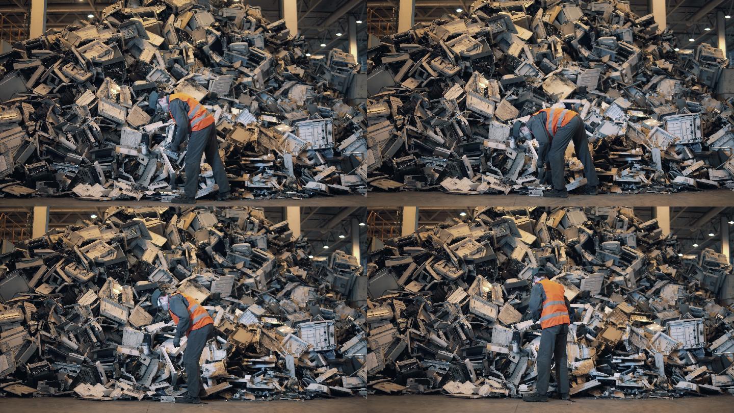 垃圾场的工作人员正在对机器碎片进行分类