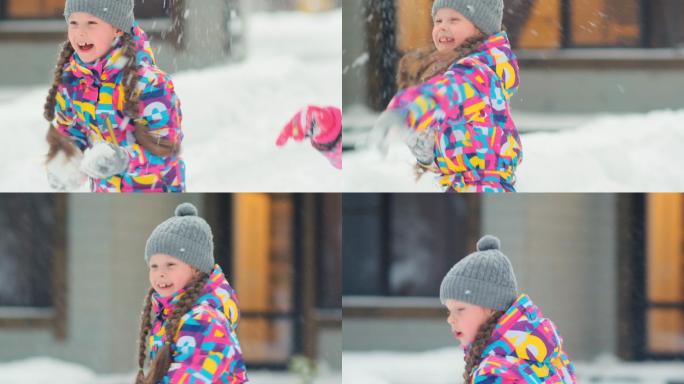 穿彩色套装的女孩在院子里和妈妈玩雪球