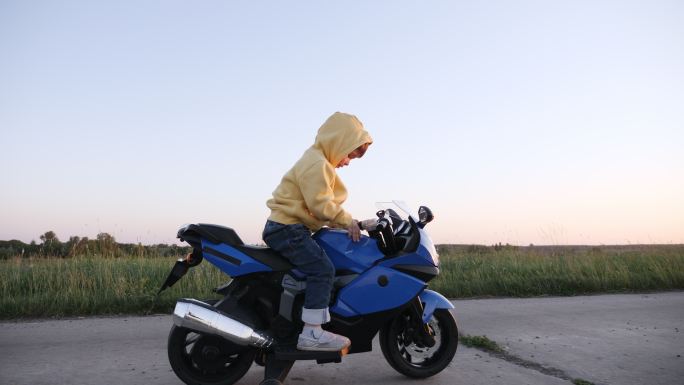 小男孩骑着一个电动摩托车玩具