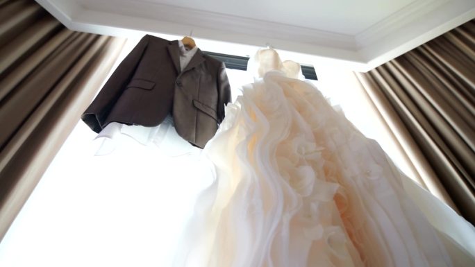 挂在窗前的婚纱和套装