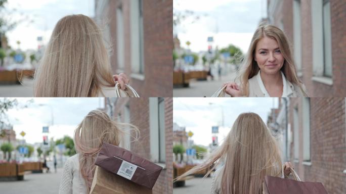 金发女郎拿着商店的购物袋走在城市的街道上