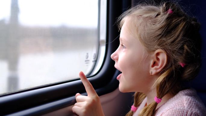 孩子在火车上，向窗外望去。