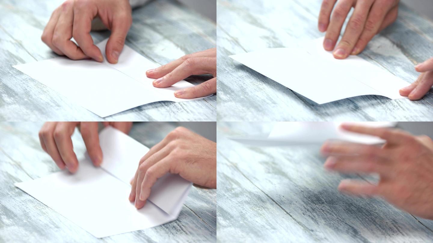 男性手折叠白色纸张。