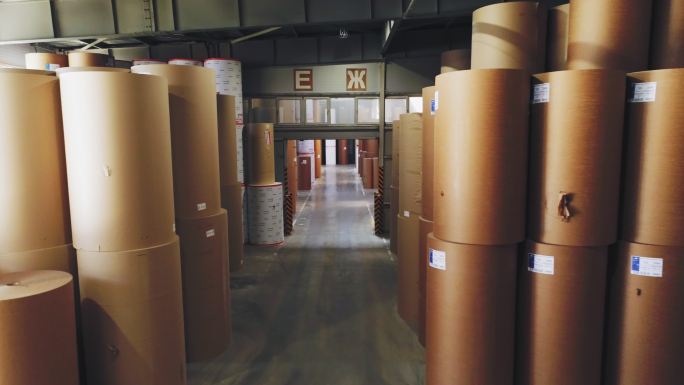 纸卷堆放在工厂宽敞的仓库中