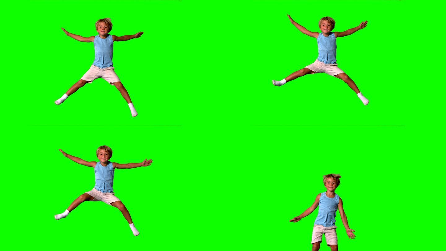男孩在绿色屏幕上伸展四肢跳跃
