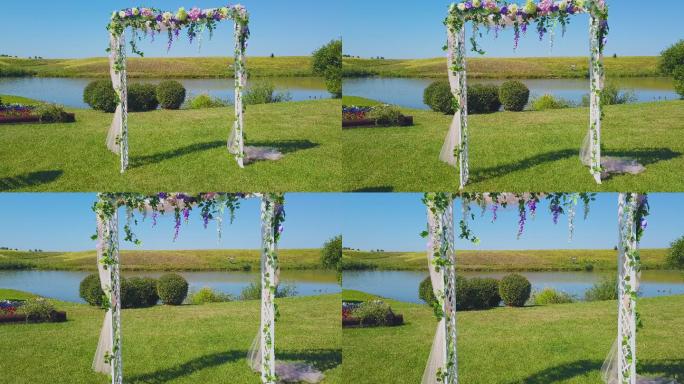 绿色草坪上鲜花点缀的婚礼拱门近景