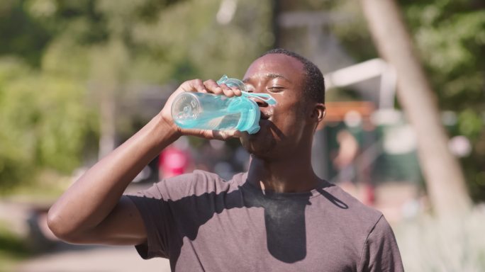 运动员在城市公园紧张锻炼后喝水