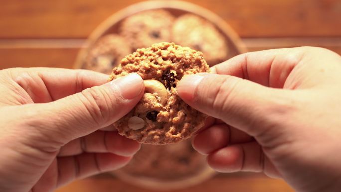 用手掰开饼干，使吃起来更容易。