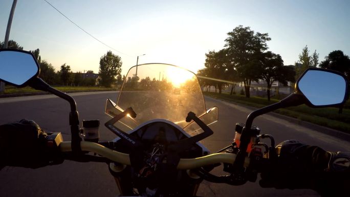 日落时分，一名摩托车手在镇上高速行驶。
