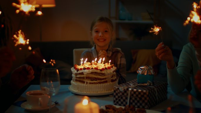可爱的小女孩在餐桌旁庆祝生日。