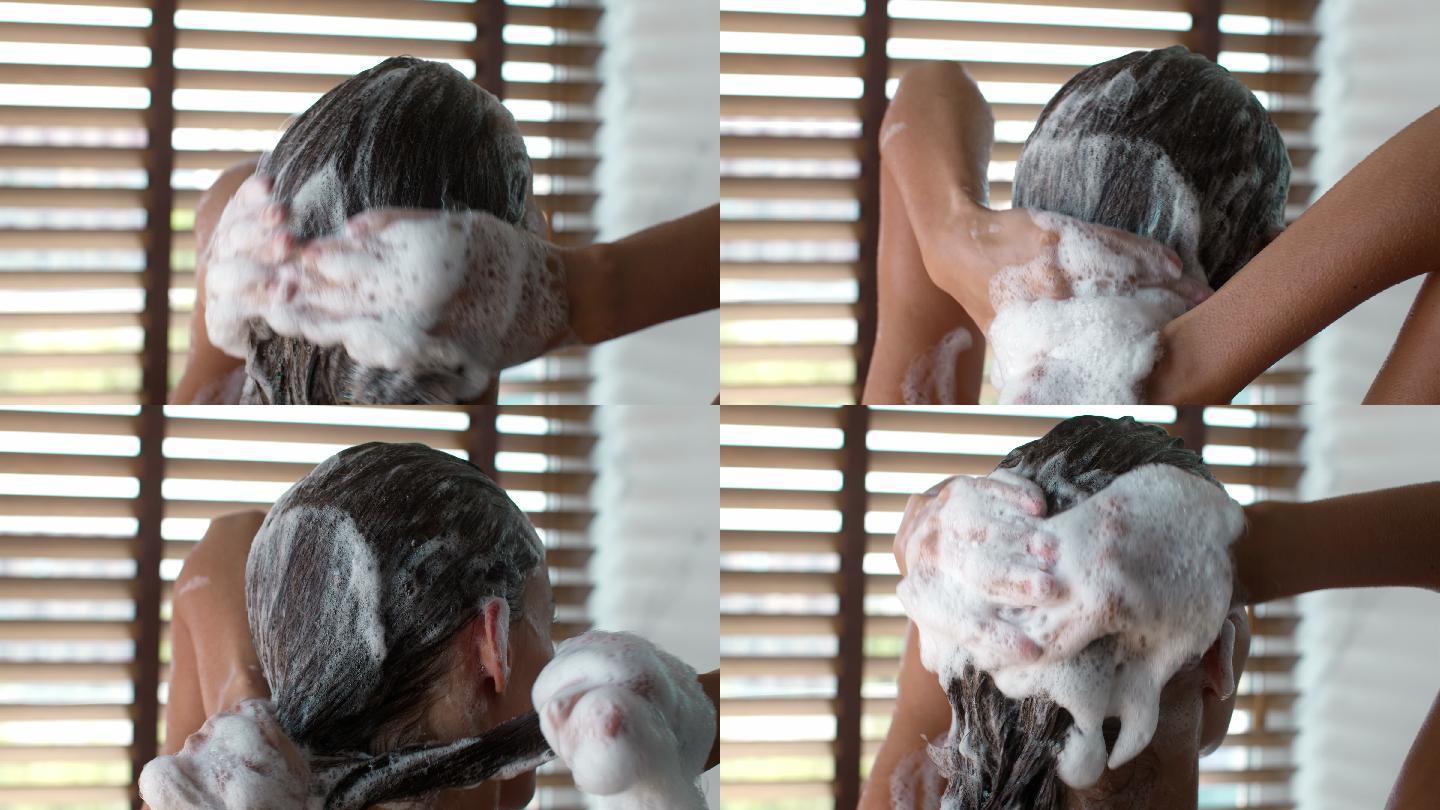 女性在浴室使用洗发水洗头的后视图