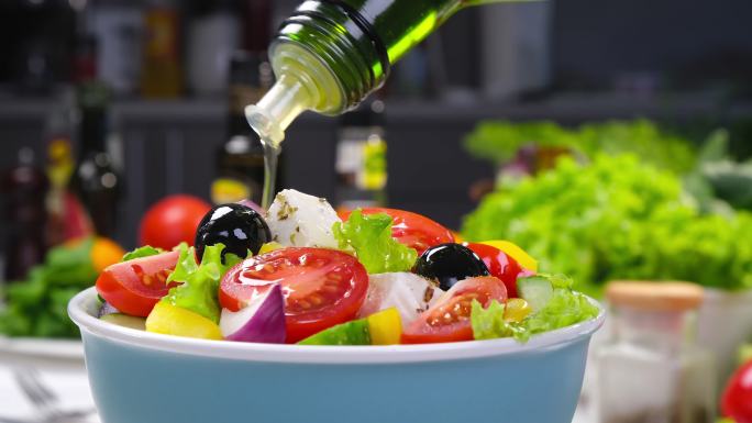 把橄榄油倒在新鲜蔬菜沙拉上