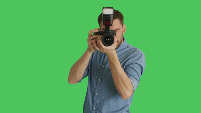 一位英摄影师用相机在绿色屏幕上拍摄。