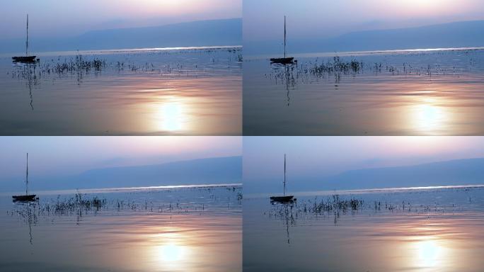 日出下，小船漂浮在平静的水面上。