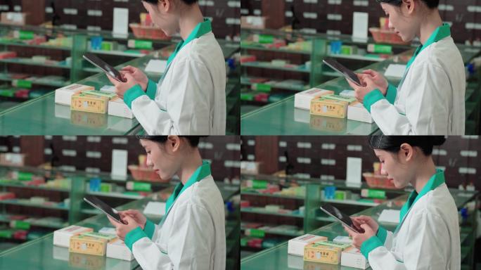 一名年轻女子在药店工作时使用数字平板电脑