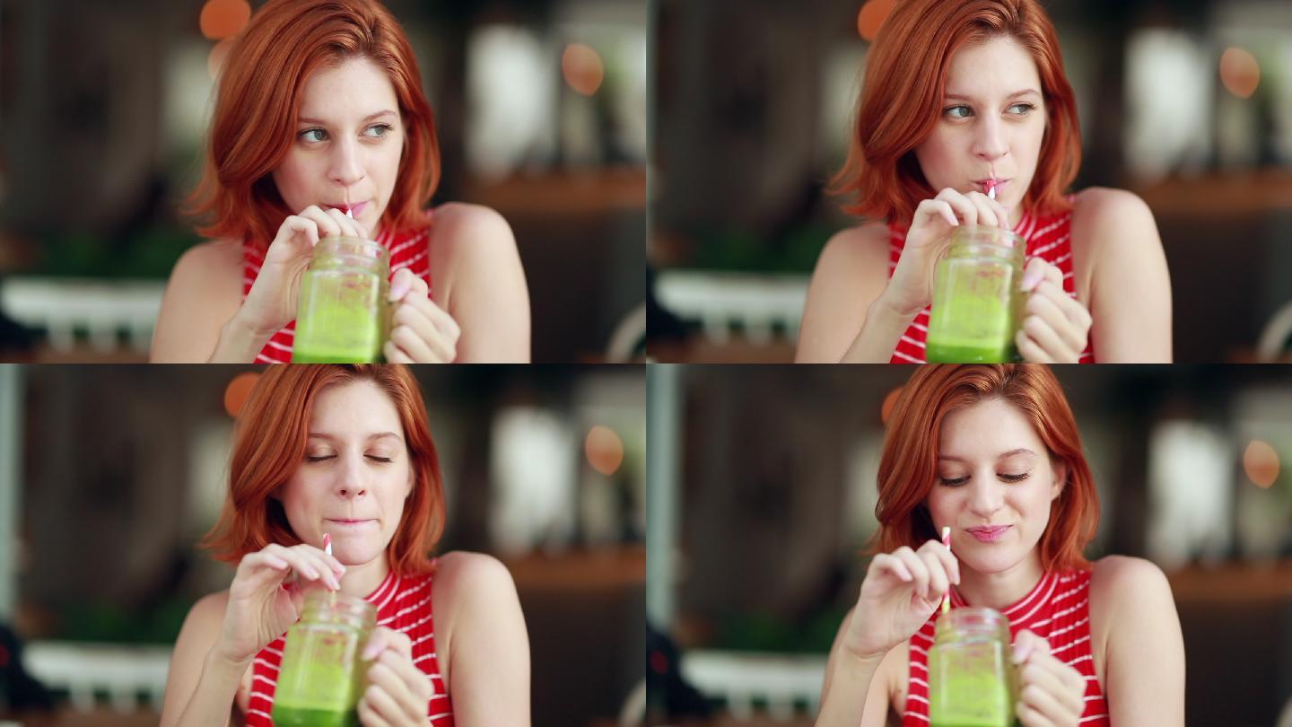 女孩喝着绿色的果汁