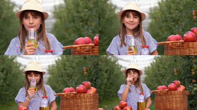 小女孩在果园里喝有机苹果汁
