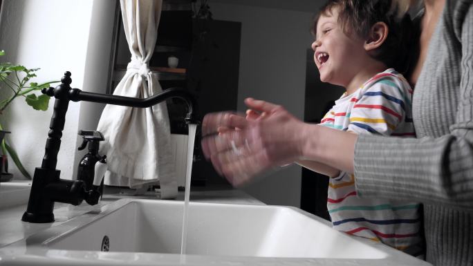 母亲给孩子洗手水龙头洗漱玩水