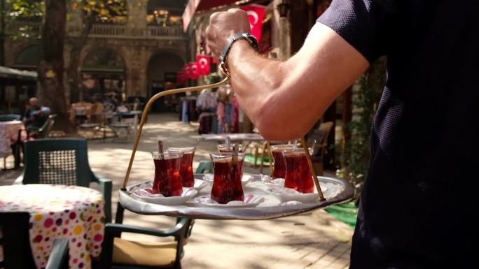 服务员用托盘端着传统的土耳其茶