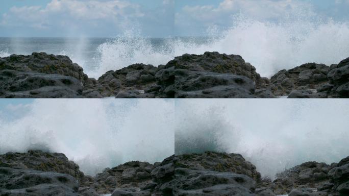 海浪席卷着岛屿上的黑色岩石