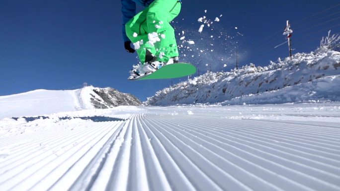 年轻的滑雪运动员升格雪橇滑板雪块飞溅