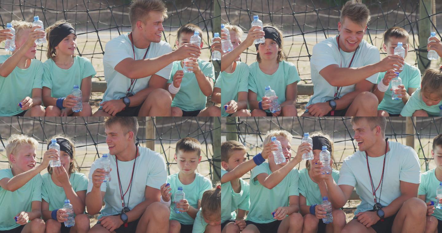 一群男孩和女孩坐在一起喝水