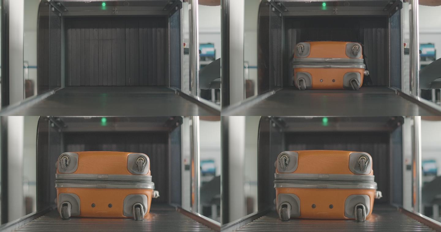 橙色行李箱从机场扫描仪中取出