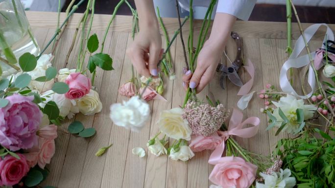 女花商在木桌上制作花束