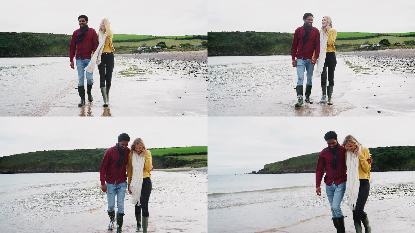 一对情侣手挽手沿着海岸线散步