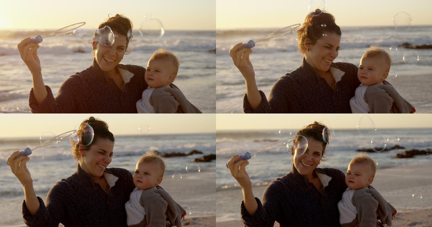 妈妈和小男孩在海滩玩泡泡棒