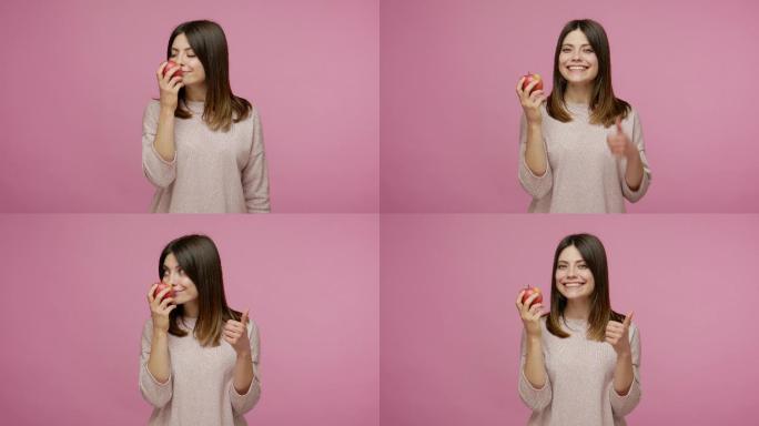 女性享受新鲜红苹果的味道竖起大拇指