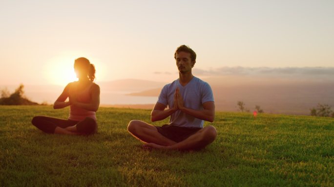 年轻人在日落时一起联系瑜伽
