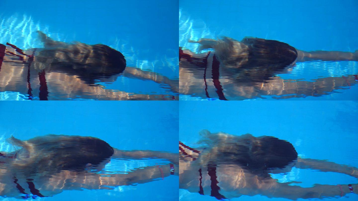 在透明清水池中游泳的年轻女子的详细视图
