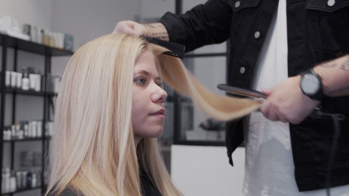 美发师对女性使用直发器