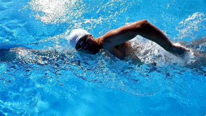 男子在游泳池中自由泳，慢动作