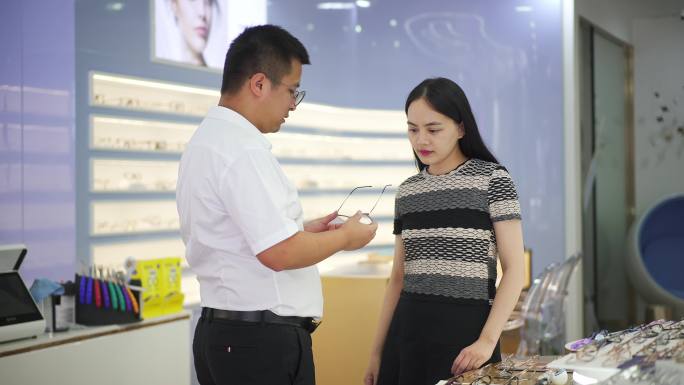 眼镜店男验光师为年轻女顾客选购眼镜服务