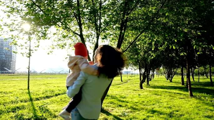 日落时分，母亲正在公园里和她的小女儿跳舞。