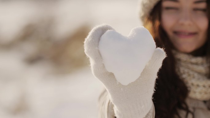 一个女人手里拿着一颗雪做的心