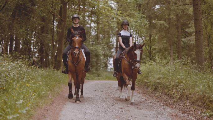 两个骑马的人缓缓地在森林中间行进。