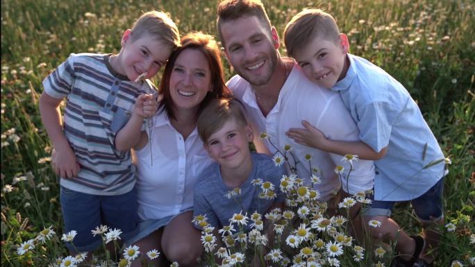 幸福的一家人在雏菊场拍照