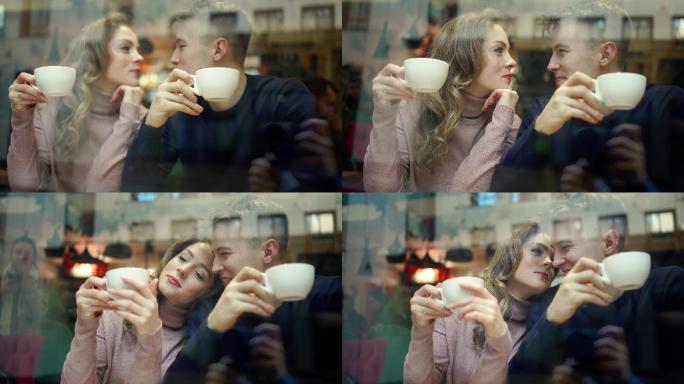 年轻幸福的浪漫情侣坐在咖啡馆的窗前