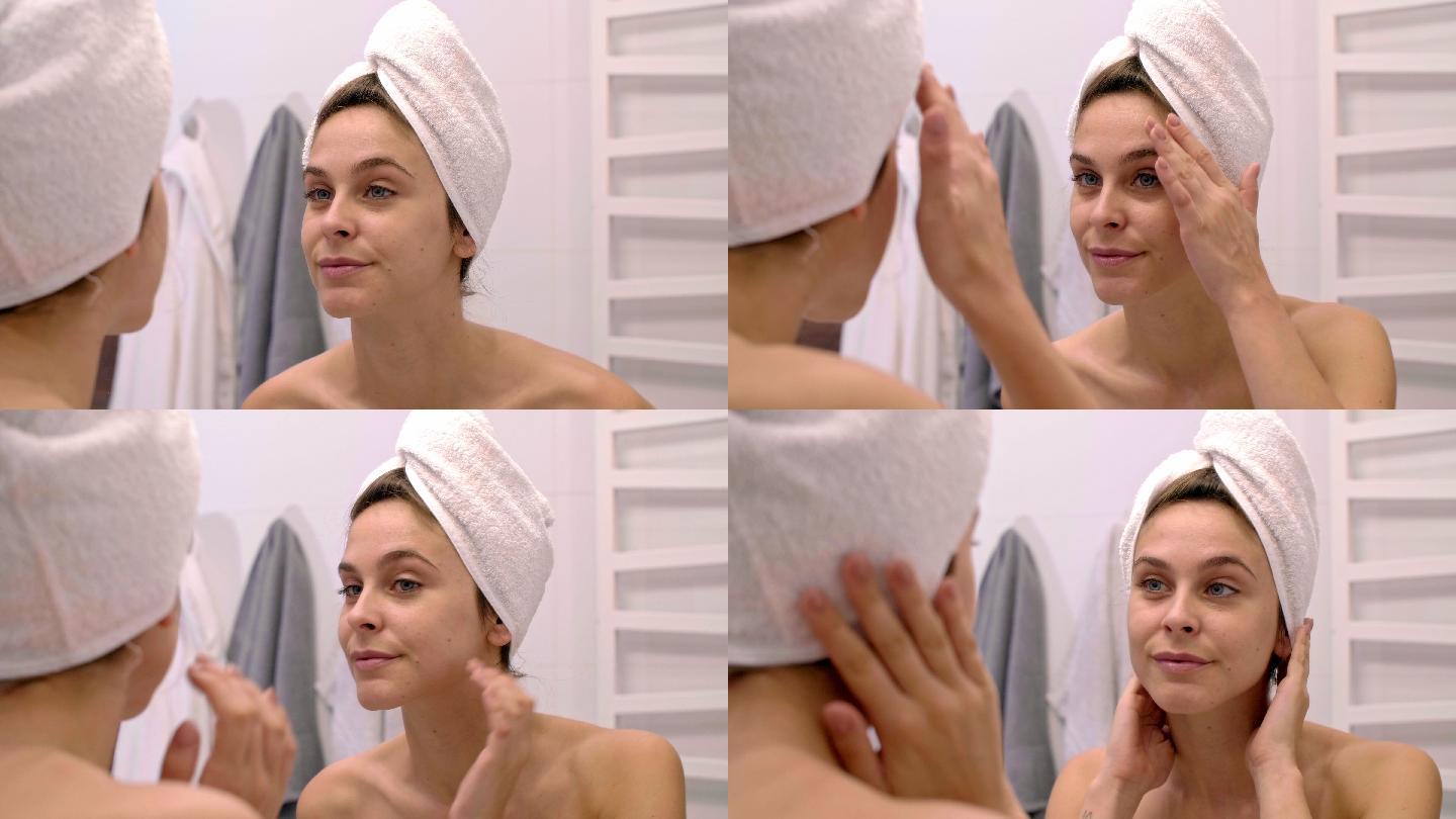 淋浴后，女人抚摸自己的脸，照镜子