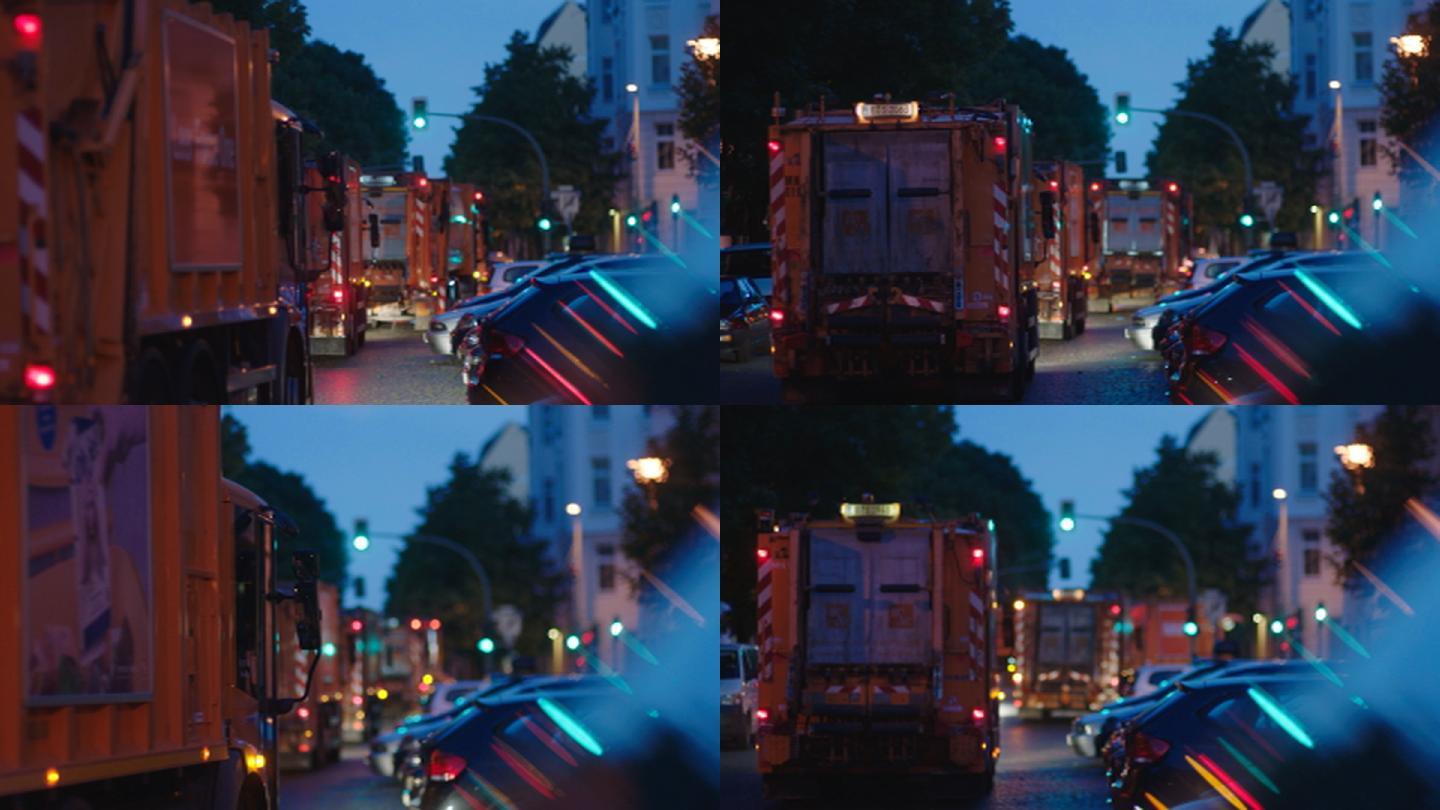 黎明时分，几辆橙色垃圾车驶过红绿灯
