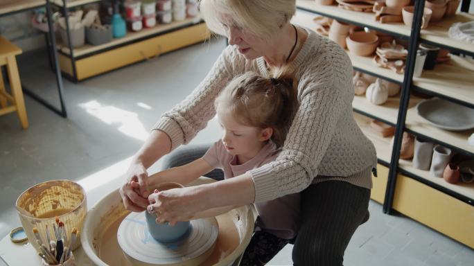 祖母教她的孙女做陶器转盘