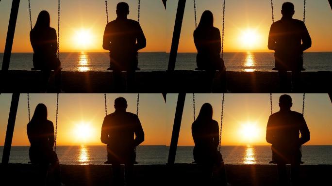 一对夫妇坐在海滩上秋千上看日出的背影