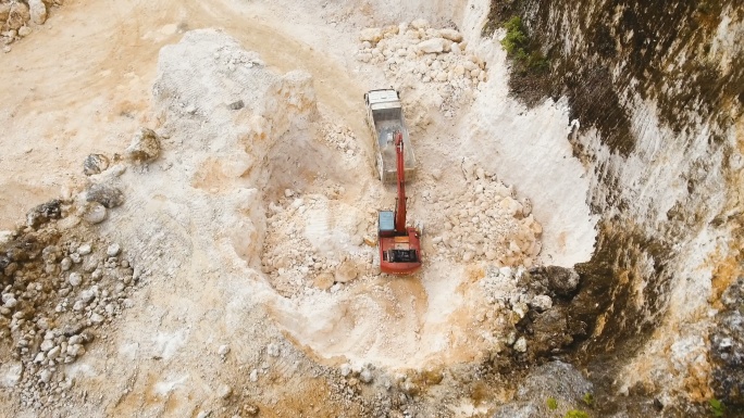 挖掘机在采石场装载卡车。