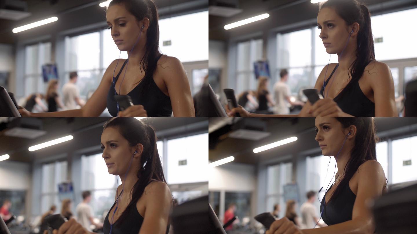 戴着耳机在健身房锻炼的女人