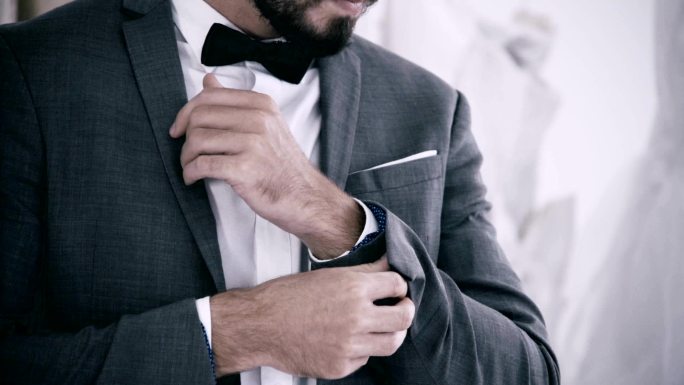 穿着正装的男人在更衣室里穿衣参加工作或婚礼。
