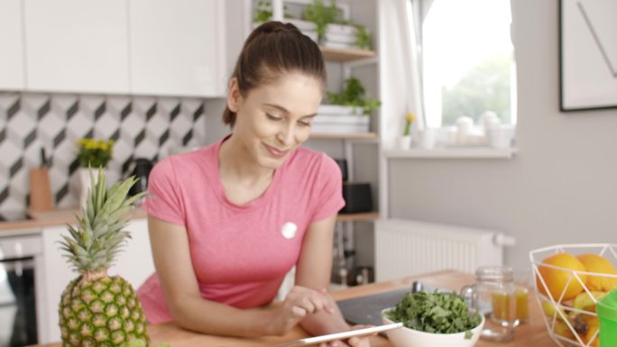 在厨房做饭时使用平板的女人